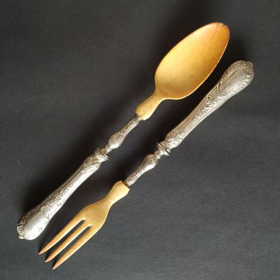 two forks and spoons are sitting on a black surface