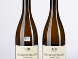 deux bouteilles de vin posées l'une à côté de l'autre sur une surface blanche