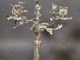 a silver candelab with flowers on it on a table