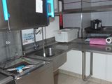 une cuisine équipée d'un évier, d'une cuisinière et d'autres appareils électroménagers