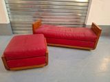 un canapé rouge et un pouf devant une porte de garage