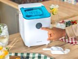 someone pointing at a small air purifier on a kitchen counter