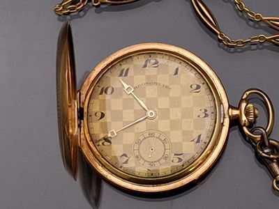 a gold pocket watch with a chain around it