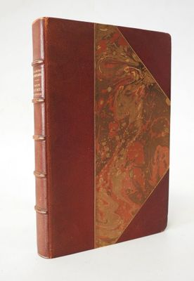 un vieux livre à la couverture rouge posé sur une surface blanche