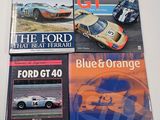 three books on a table with a picture of a racing car and a blue orange car