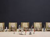 de nombreuses figurines représentant des personnes debout devant un cadre photo