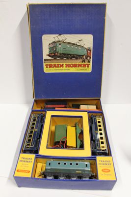 une boîte bleue contenant un train, posée sur une surface blanche