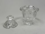 a glass jar and a glass candle holder on a table