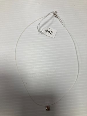 un gros plan d'un collier posé sur une table, avec une étiquette de prix