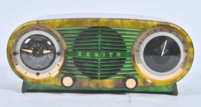 une radio verte et dorée posée sur une table blanche
