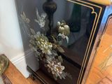 a black and gold cabinet with flowers on it