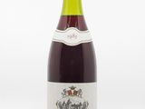 bottle of red wine on a white surface with a white background