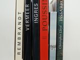 several books are stacked on top of each other on a white surface