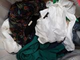 a pile of clothes that is sitting on a bed