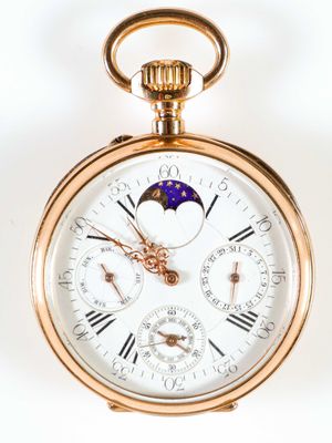 gros plan d'une montre de poche en or sur fond blanc