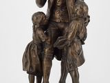 statue en bronze représentant un homme assis sur une chaise avec deux enfants