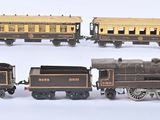 quatre types différents de petits trains miniatures posés sur une surface blanche