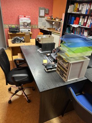 a desk with a computer and a chair in a room