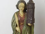 a statue of a woman holding a lantern next to a statue of a man