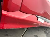 a close up of a red car parked on the street