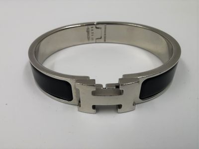 bracelet posé sur un fond blanc, muni d'une boucle noire et argentée
