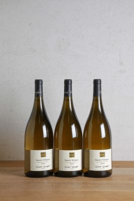 trois bouteilles de vin posées sur une table en bois