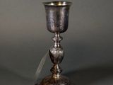 an antique silver plated cup and saucer on a grey background