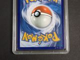 a pokemon card in a plastic case on a table