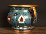 a blue vase with a gold handle sitting on a table
