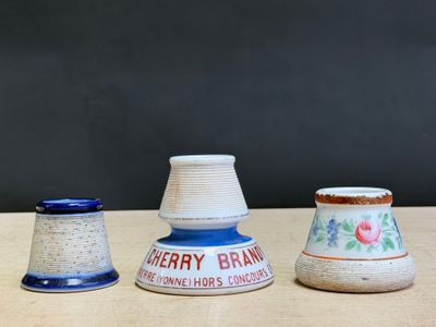 three vases sitting on a table with a black background