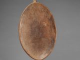 an old wooden plate sitting on top of a black stand
