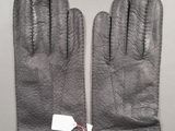 pair of black leather gloves with tags on them on a table