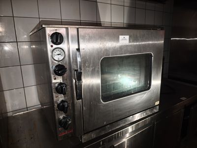 un four en acier inoxydable posé sur un plan de travail dans une cuisine