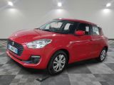 Une Suzuki Swift rouge est garée dans une pièce au sol à carreaux.