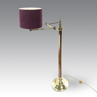 une lampe de table en laiton surmontée d'un abat-jour violet