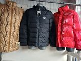three jackets hanging on a clothes rack in a room