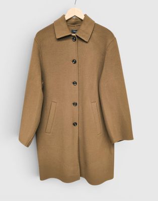 Ce manteau est en laine et possède un col boutonné.