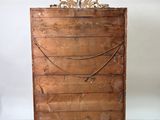 a wooden chest of drawers in a room with pictures on the wall