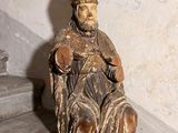 une statue représentant un homme assis sur un escalier