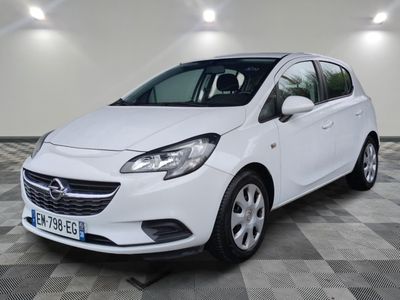 L'Opel blanche est garée dans une pièce au sol carrelé.