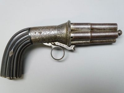 un gros plan d'un pistolet posé sur une table, sur lequel est posé un anneau