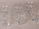 six shot glasses are lined up on a white surface