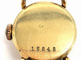 a close up of a gold pocket watch on a white surface