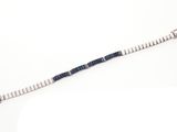 une photo d'un long bracelet composé de perles argentées et bleues