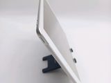 a white tablet computer sitting on a stand on a table