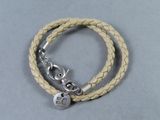 bracelet en cuir orné d'une breloque en argent sur fond gris