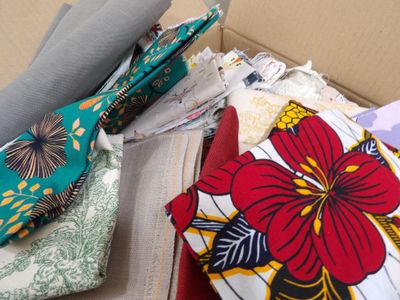 many pieces of fabric in a box on the table