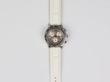 a close up of a white watch on a white surface