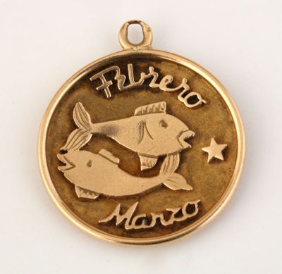 un gros plan d'une médaille d'or sur laquelle figure un poisson