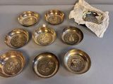 six bols en argent et un sac de pièces d'argent posés sur une table